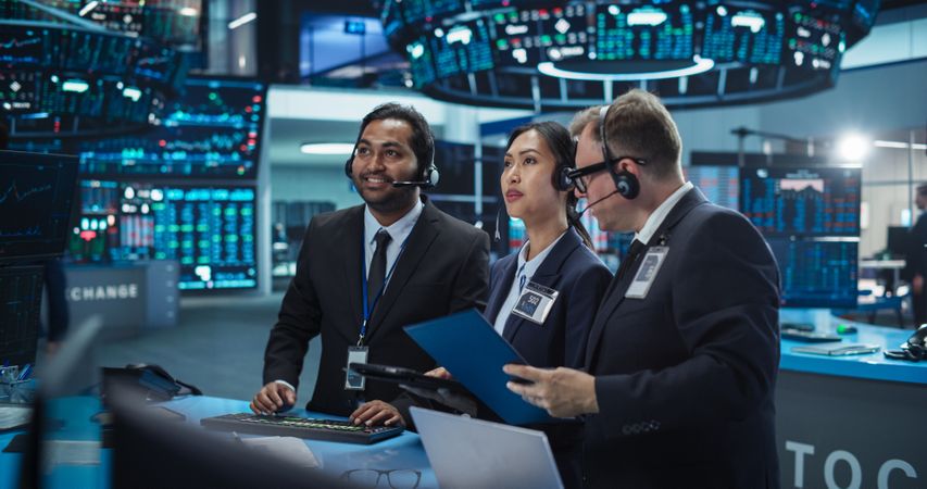 Work Day in an International Stock Exchange Hall: Multiethnic Specialists Monitoring Equity and Share Markets on Tablets and Computers, Working on Maximizing Profits for Corporate Business Partners