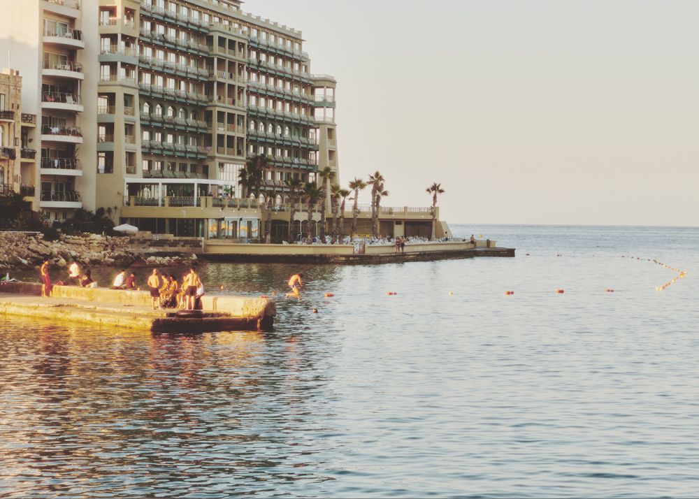 Men on small dock relaxing jumping into the water