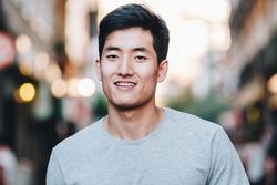 Confident Asian man walking along city street