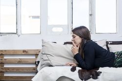 Woman lying on sofa in front of laptop
