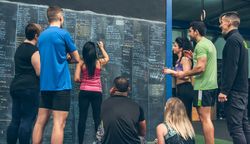 Athlete woman writing down results on the gym board