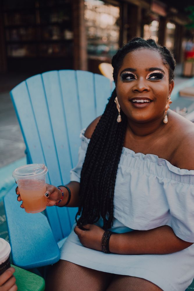 Black modern woman drinking cold beverage at coffee shop