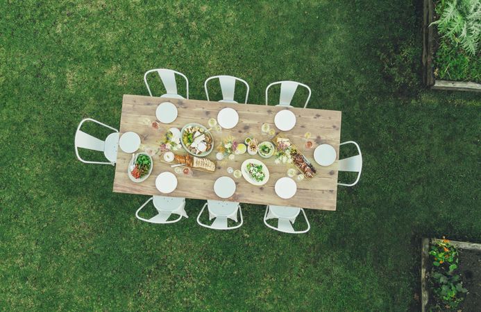 Aerial view of table setting outdoors in garden restaurant with empty chairs