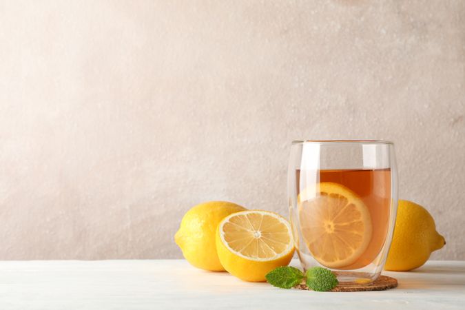 Glass of tea with lemon, mint, honey, dipper and ginger on wooden background ,copy space