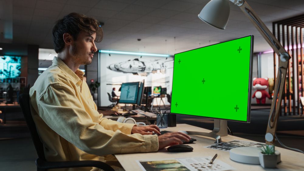 Man Using Desktop Computer with Mock-up Green Screen Chromakey.