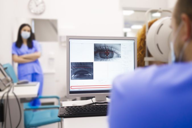 Man checking screen of scan of patient’s eye