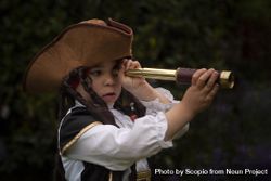 Girl in Pirate costume looking through telescope 0Vxr34