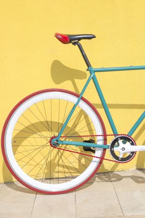 Bike outside on bright yellow wall, vertical