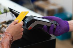 Crop woman paying with plastic card on terminal