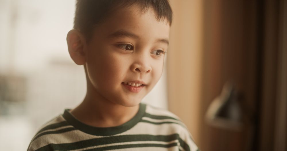 Portrait of a Little Cute Asian Boy Smiling At Home In His Sunny Room.