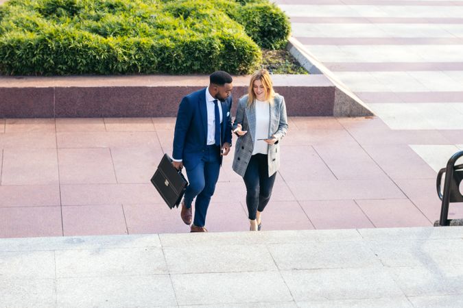 Business colleagues going to the office talking about the company while walking up the stairs