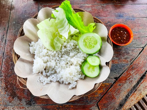 The traditional Indonesian food dish is called Ayam Penyet or fried chicken with rice and vegetables without chicken and tempeh