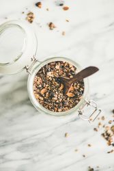 Top view glass container of homemade granola, with copy space