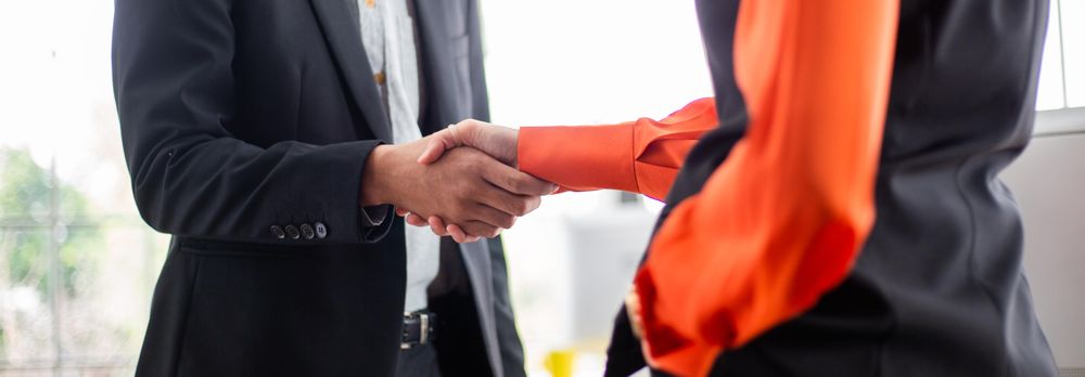 Banner of man and woman shaking hands in office