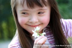 A young girl holding a flower in her hand 4davnb