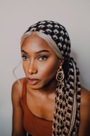 Black woman wearing headscarf and brown dress