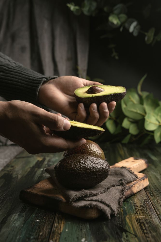 Person hands holding avocados