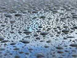 A wet surface with many small drops of water scattered across it