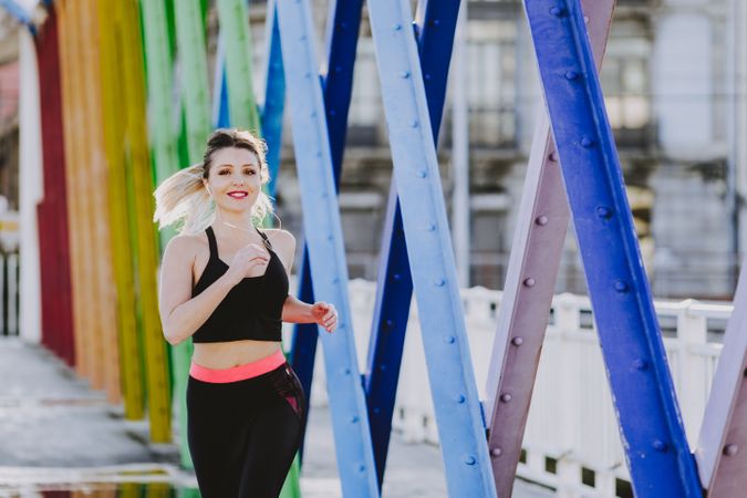 Woman with earphones running on street