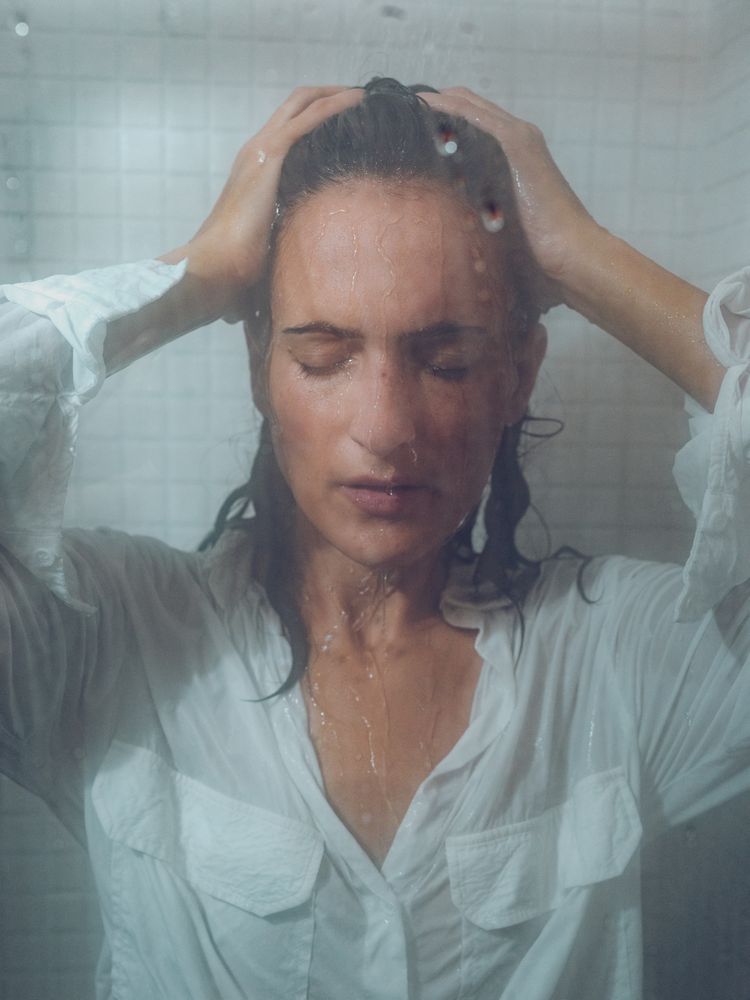 Seductive female in wet shirt in shower cabin