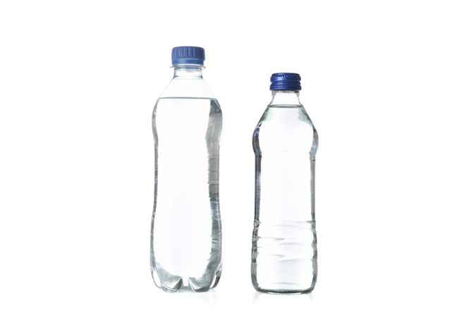 Two plastic water bottles in plain room