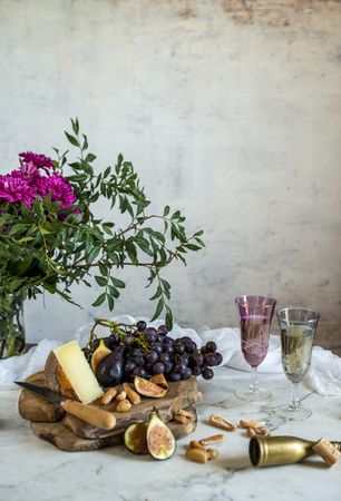 apes next to piece of cheese on cutting boards near pink flowers