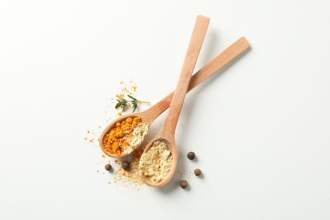 Top view of two wooden spoons full of spice