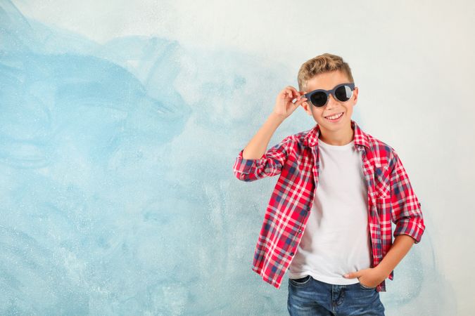 Steep boy with sunglasses against color background, space for text
