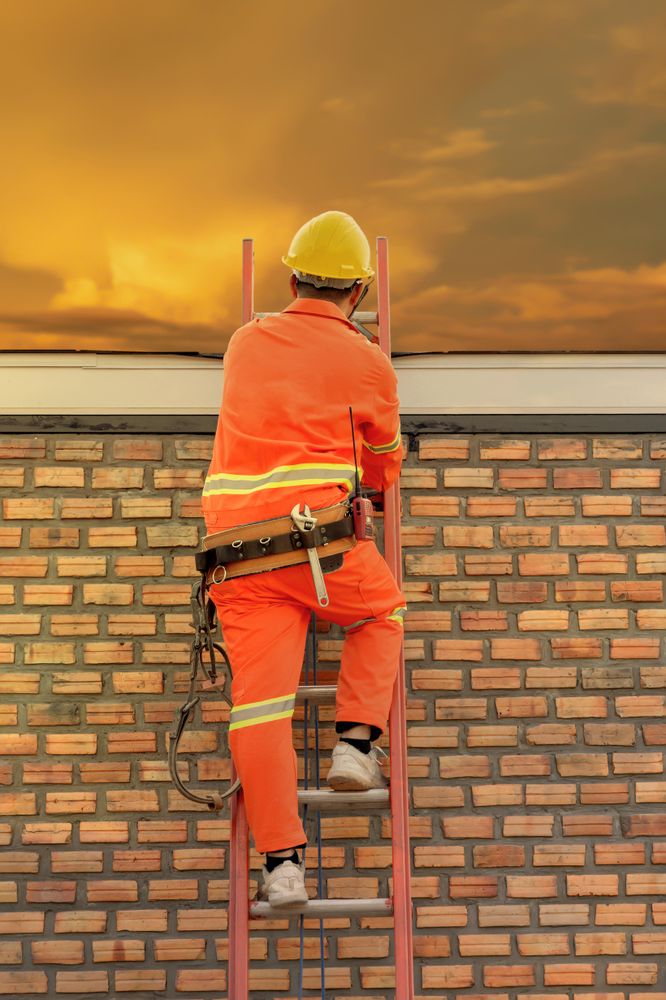 Man with yellow bump cap climbing a ladder
