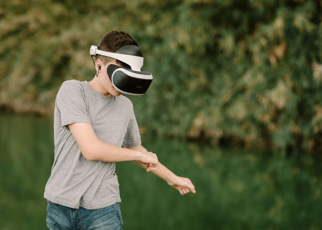 Young teenager with virtual reality glasses outdoors