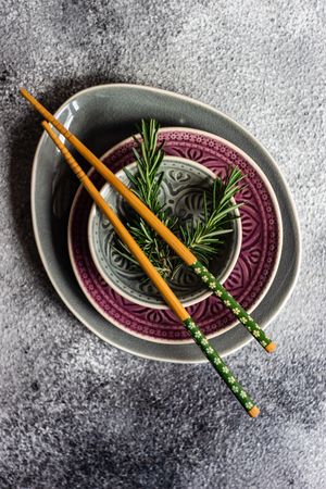 Top view of Asian table setting with chopsticks and rosemary