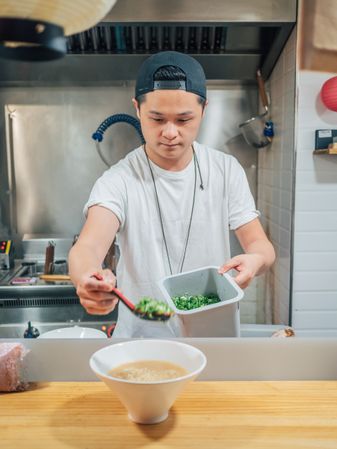 Young cook serving bowl with delicious ramen
