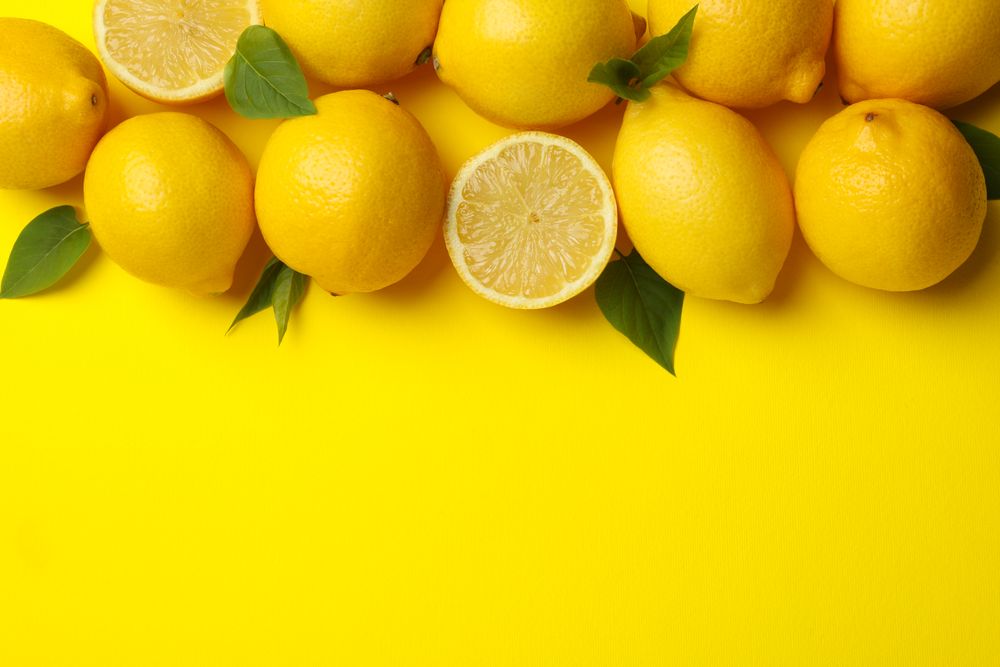 Lemons on yellow background, top view. Fresh fruit