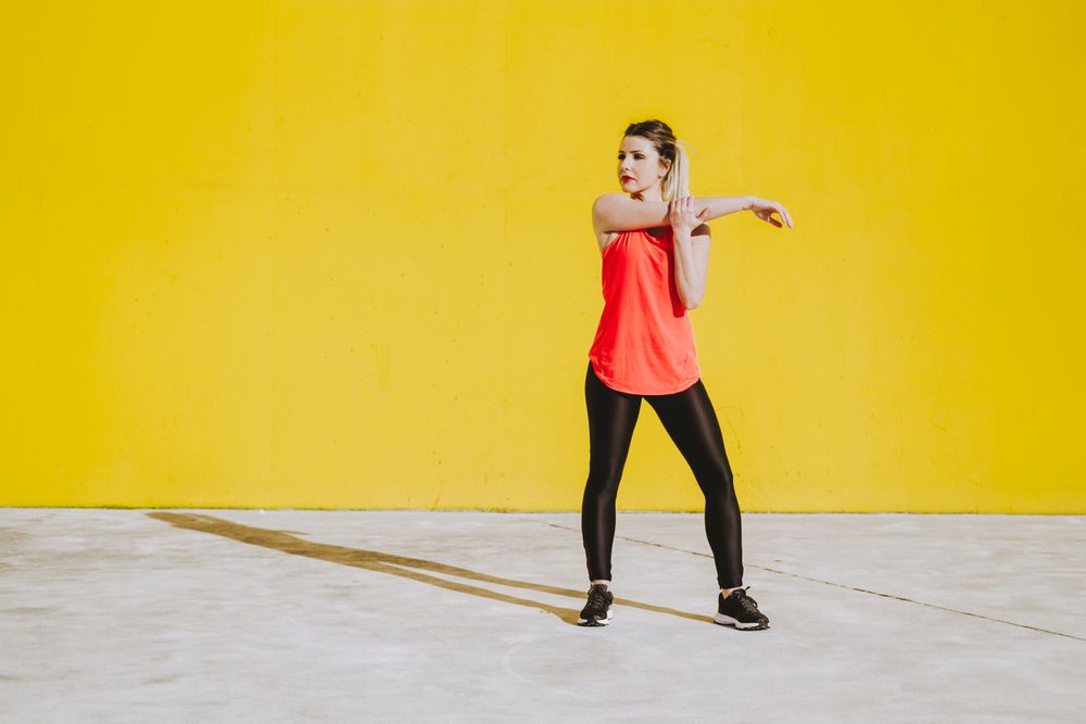 Woman stretching arms near wall