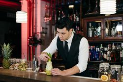 Barman working preparing drink in a glass