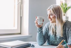 Positive woman holding cup in office