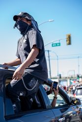 Los Angeles, CA, USA — June 7th, 2020: man standing out of passenger window of car at protest
