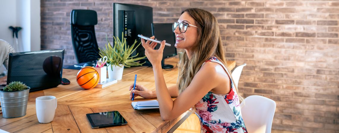 Office worker talking mobile phone with speaker