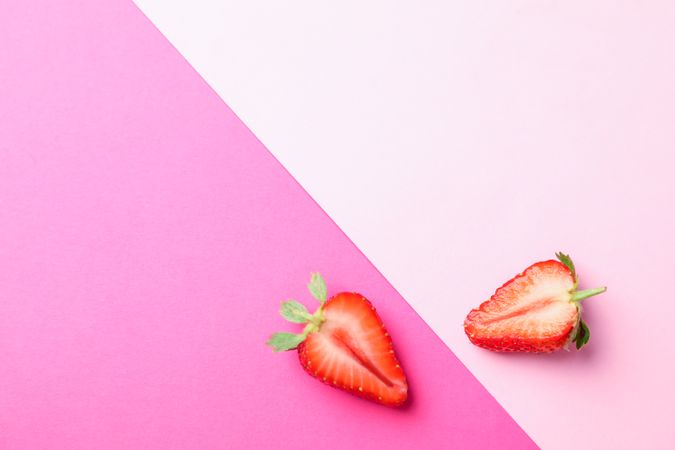 Half of strawberries on two color background, space for text. Summer sweet fruits and berries