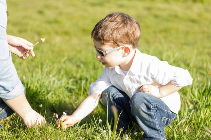 Mother and son picking flowers in a field