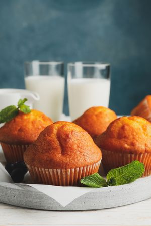 Composition with muffins and milk on wooden background