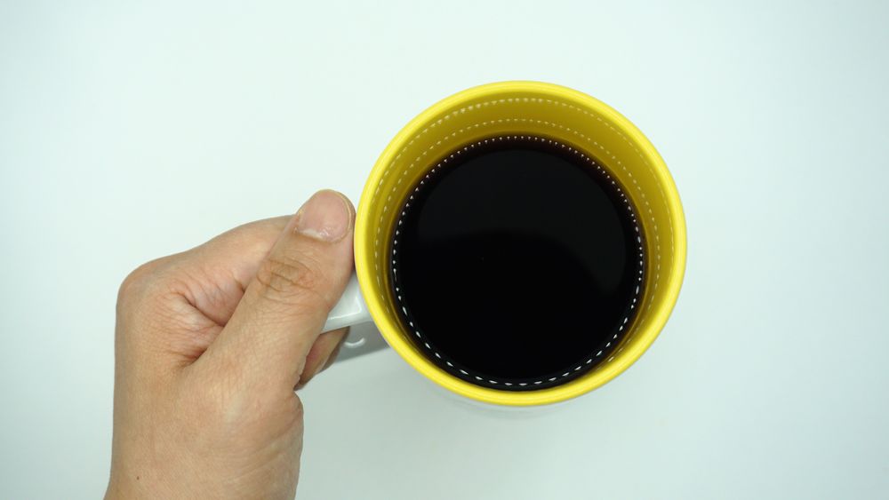 hand holding a cup of coffee