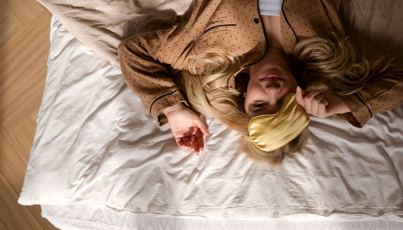 Overhead view of woman lying on bed