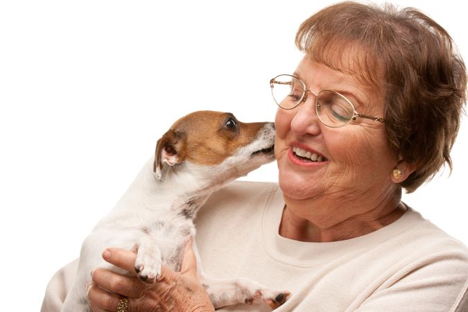 Happy Attractive Older Woman with Puppy on White