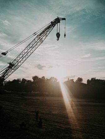 Silhouette of crane near grass field