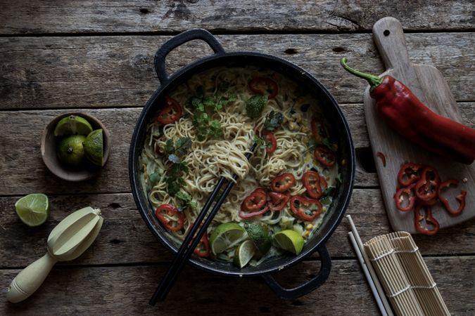Green curry noodles in pot on table