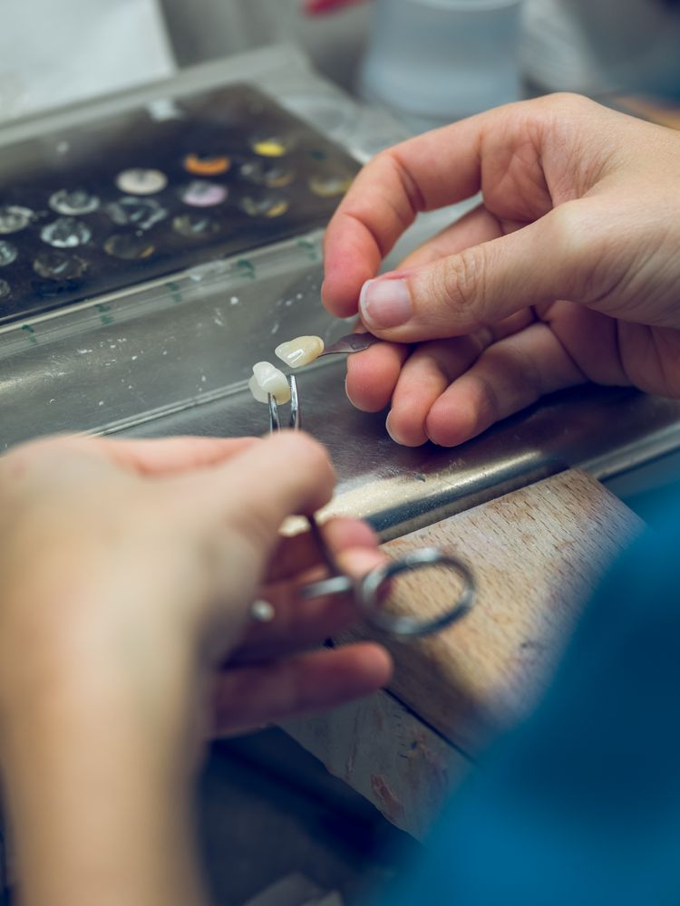 Anonymous dental technician working with artificial teeth