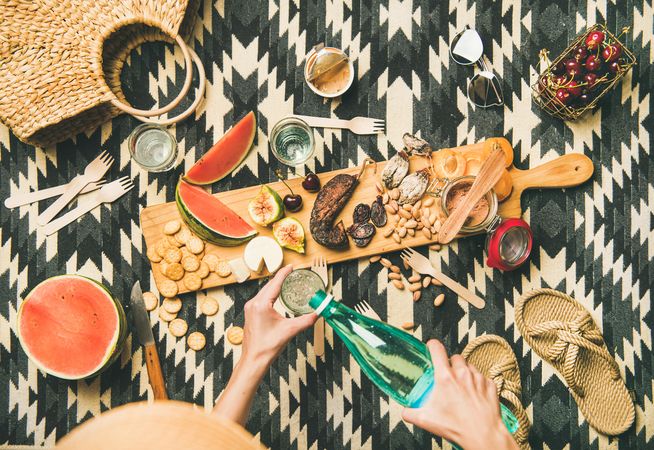 Summer picnic on pueblo pattern blanket, with board of pate, meats, and fruit