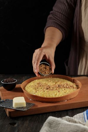Woman's Hands Sprinkle Peanuts on Sweet Martabak or Terang Bulan