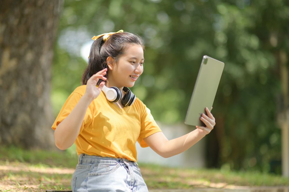 Asian woman greets her friends with a tablet.